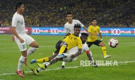 Pesepak bola timnas Indonesia Rudolof Yanto Basna (bawah) berebut bola dengan pesepak bola Timnas Malaysia Mohamadou Sumareh (tengah) saat pertandingan kualifikasi Piala Dunia 2022 Grup G Zona Asia di Stadion Bukit Jalil, Kuala Lumpur, Malaysia, Selasa (19/11/2019). 