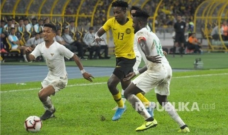 Pesepak bola Timnas Indonesia Teuku Muhammad Ichsan (bawah) berebut bola dengan pesepak bola Timnas Malaysia Mohamadou Sumareh (tengah) saat pertandingan kualifikasi Piala Dunia 2022 Grup G Zona Asia di Stadion Bukit Jalil, Kuala Lumpur, Malaysia, Selasa (19/11/2019). 