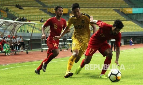 Pesepak bola Timnas Indonesia U-22 R.Lastori (kanan) berebut bola dengan pesepak bola Bhayangkara FC Arif Setiawan (tengah) pada laga pertandingan persahabatan di Stadion Patriot Candrabhaga, Bekasi, Jawa Barat, Rabu (6/2/2019). 