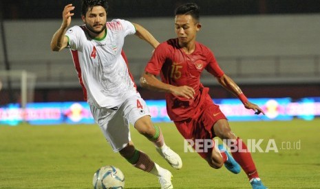 Pesepak bola timnas Indonesia U-22 Sani Rizki Fauzi (kanan) menggiring bola dengan dibayangi pesepak bola Timnas Iran U-23 Aref Gholami pada pertandingan sepak bola persahabatan di Stadion I Wayan Dipta, Gianyar, Bali, Rabu (13/11/2019).