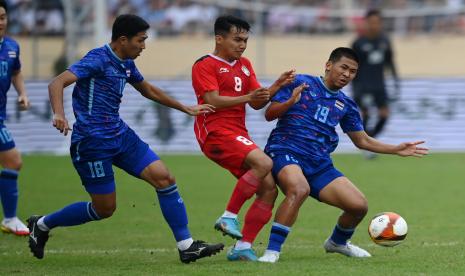 Pesepak bola Timnas Indonesia Witan Sulaeman (tengah) berebut bola dengan pesepak bola Timnas Thailand Chayapipat Supanpasuch (kanan) dalam pertandingan semifinal sepak bola SEA Games 2021 Vietnam di Stadion Thien Truong, Nam Dinh, Vietnam, Kamis (19/5/2022). 