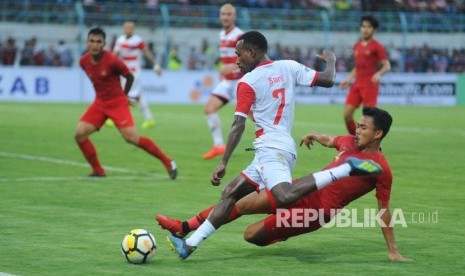 Pesepak bola Timnas U-22 Asnawi Mangku Alam (kanan) berusaha menghentikan pesepak bola Madura United FC (MU) Engelberd Sani (tengah) saat laga uji coba di Stadion Gelora Bangkalan (SGB) Bangkalan, Jawa Timur, Selasa (12/2/2019).