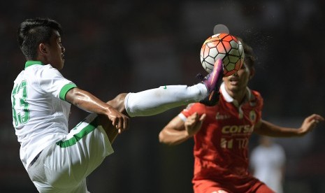 Winger Timnas U-22 Febri Haryadi (kiri) berebut bola dengan pemain Persija Jakarta Rezaldi Hehanusa (kanan) dalam pertandingan uji coba di Stadion Patriot Chandrabhaga, Bekasi, Jawa Barat, Rabu (5/4).