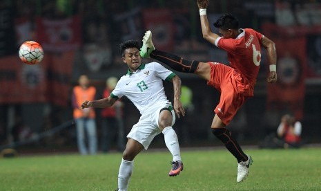 Pesepak bola Timnas U-22 Febri Haryadi (kiri) berebut bola dengan pesepak bola Persija Jakarta Maman Abdurrahman (kanan) dalam pertandingan uji coba di Stadion Patriot Chandrabhaga, Bekasi, Jawa Barat, Rabu (5/4).