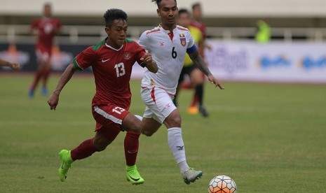 Pesepak bola Timnas U-22 Indonesia Febri Hariyadi (kiri) menggiring bola dibayangi pesepak bola Timnas Myanmar Yan Aung Kyaw pada pertandingan persahabatan di Stadion Pakansari, Cibinong, Bogor, Jawa Barat, Selasa (21/3). 