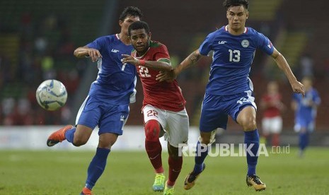 Pesepak bola Timnas U-22 Yabes Roni (tengah) berebut bola dengan pesepak bola Filipina U-22 Junell Mark Bautista (kiri) dan Joshua Jake Crommen pada babak penyisihan Grup B SEA Games XXIX di Stadion Shah Alam, Selangor, Malaysia, Kamis (17/8). Indonesia menang atas Filipina dengan skor 3-0. 