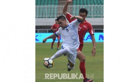 Pesepak bola timnas U-23 Uzbekistan Kenjabaev Islom (kiri) berebut bola dengan pesepak bola timnas U-23 Korea Utara Kim Nam Il pada laga perdana PSSI Anniversary Cup 2018 di Stadion Pakansari, Bogor, Jawa Barat, Jum'at (27/4). 