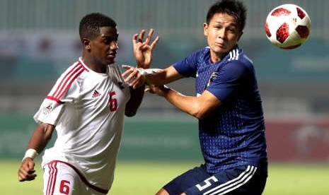 Pesepak bola timnas UEA Majid Salim (kiri) berebut bola dengan pemain Jepang Daiki Sugioka pada babak semifinal cabang sepak bola putra Asian Games 2018 di Stadion Pakansari, Bogor, Jawa Barat, Rabu (29/08).