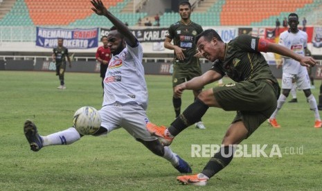 Pesepak bola Tira Persikabo Guntur Triaji (kanan) menendang bola yang dihadang pesepak bola Arema FC Riky Kayame (kiri) pada lanjutan Liga 1 2019 di Stadion Pakansari, Cibinong, Bogor, Jawa Barat, Kamis (24/10/2019).