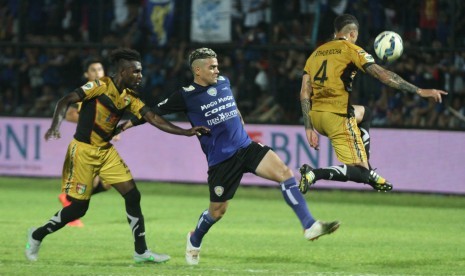 Pesepakbola Arema Cronus, Cristian Gonzales (tengah), berusaha melewati pesepakbola Mitra Kukar, Arthur Do Santos (kanan) dan Riski Pelu (kiri), dalam pertandingan semifinal Piala Jenderal Sudirman leg kedua di Stadion Kanjuruhan, Malang, Jawa Timur, Ahad 