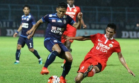 Pesepakbola Arema FC Ahmad Bustomi (kiri) berusaha mempertahankan bola dari hadangan pesepakbola Persija Jakarta, Sandi Darma Sutte (kanan) dalam pertandingan Piala Presiden di Stadion Kanjuruhan, Malang, Jawa Timur, Sabtu (11/2). 