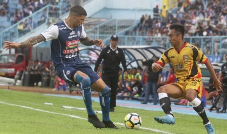 Pesepakbola Arema FC, Arthur Cunha (kiri) berusaha merebut bola dari pesepakbola Mitra Kukar, Dedi Hartono (kanan) dalam pertandingan Liga I di Stadion Kanjuruhan, Malang, Jawa Timur, Sabtu (24/3). Mitra Kukar menahan imbang Arema FC dengan skor akhir 2-2.