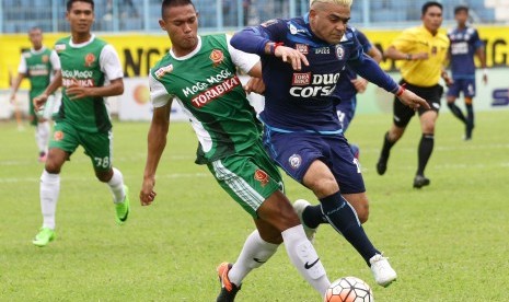 Pesepakbola Arema FC, Cristian Gonzales (kanan) berusaha melewati hadangan pesepakbola PS TNI, Andi Setyo Nugroho (kiri) dalam pertandingan Piala Presiden Grup 2 di Stadion Kanjuruhan, Malang, Jawa Timur, Kamis (16/2).