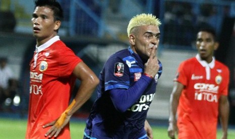 Pesepakbola Arema FC, Cristian Gonzales (tengah) melakukan selebrasi usai mencetak gol di gawang Persija Jakarta yang dikawal pesepakbola Sandi Darma Sutte (kiri) dalam pertandingan Piala Presiden di Stadion Kanjuruhan, Malang, Jawa Timur, Sabtu (11/2). 