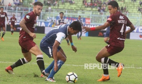 Pesepakbola Arema FC, Dedik Setiawan (tengah) berusaha melepaskan diri dari hadangan pesepakbola PSM Makassar, Wasyiat Hasbullah (kanan) dan Marc Anthony Klok (kiri), dalam pertandingan GOJEK LIGA I di Stadion Kanjuruhan, Malang, Jawa Timur, Ahad (13/5).