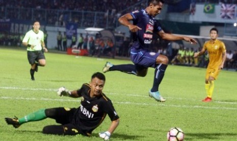 Pesepakbola Arema FC Hendro Siswanto (kanan) melompat untuk menghindari tubuh penjaga gawang Bhayangkara FC, Panggih Prio Sembodo (kiri) dalam pertandingan Piala Presiden Grup E di Stadion Kanjuruhan, Malang, Jawa Timur, Selasa (30/1). 