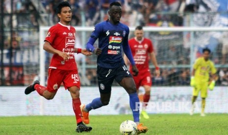 Gelandang Arema FC Makan Konate (kanan) berusaha melepaskan diri dari adangan gelandang Persija Jakarta Sandi Darman Sute (kiri) dalam lanjutan Liga 1 di Stadion Kanjuruhan, Malang, Sabtu (23/11). 