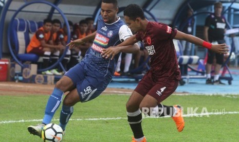 Pesepakbola Arema FC, Thiago Furtuoso (kiri) berusaha mempertahankan bola dari hadangan pesepakbola PSM Makassar, Wasyiat Hasbullah (kanan) dalam pertandingan GOJEK LIGA I di Stadion Kanjuruhan, Malang, Jawa Timur, Ahad (13/5).