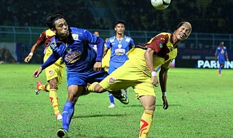 Pesepakbola Arema Indonesia Cronous, Beny Wahyudi (kiri) berebut bola dengan pesepakbola Sriwijaya FC, Jeki Arisandi (kanan) dalam pertandingan babak delapan besar, Grup A, Inter Island Cup di Stadion Kanjuruhan, Malang, Jawa Timur, Selasa (21/1).Arema Cro