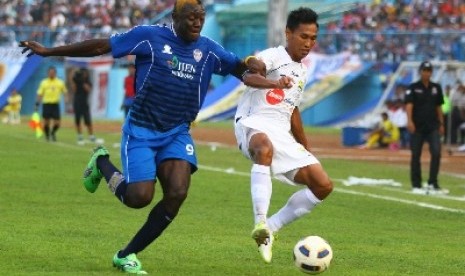 Pesepakbola Arema Indonesia, Herman Dzumafo (kiri) berusaha mencuri bola 