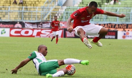 Pesepakbola Bhayangkara FC, Antoni Putro Nugroho (kanan) melompat untuk menghindari hadangan pesepakbola PS TNI, Rinto Ali (kiri) dalam pertandingan Piala Presiden di Stadion Kanjuruhan, Malang, Jawa Timur, Sabtu (11/2).