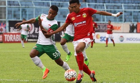 Pesepakbola Bhayangkara FC, Jajang Mulyana (kanan) berusaha mempertahankan bola dari hadangan pesepakbola PS TNI, Manahati Lestusen (kiri) dalam pertandingan Piala Presiden di Stadion Kanjuruhan, Malang, Jawa Timur, Sabtu (11/2). Bhayangkara FC menaklukkan