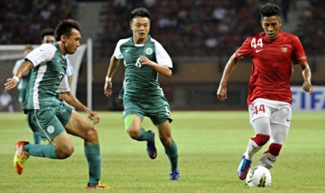 Pesepakbola Indonesia Bima Ragil (kanan) dikawal ketat pesepakbola Macau Chan Man (tengah) dalam pertandingan kualifikasi grup E Piala Asia (AFC) di Stadion Utama Riau, Pekanbaru, Riau, Selasa (10/7) malam.