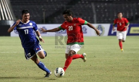 Pesepakbola Indonesia Ilham Udin berebut bola dengan pesepakbola Filipina Junel Mark saat laga grup G kualifikasi Piala AFC 2013 di Stadion Gelora Bung Karno, Kamis (10/10).  (Republika/Yasin Habibi)