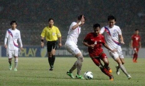 Pesepakbola Indonesia Muhammad Hargianto (merah) berebur bola dengan pemain Korea Selatan dalam laga kualifikasi group G AFC U-19 di Gelora Bung Karno, Senayan, Jakarta, Sabtu (12/10).