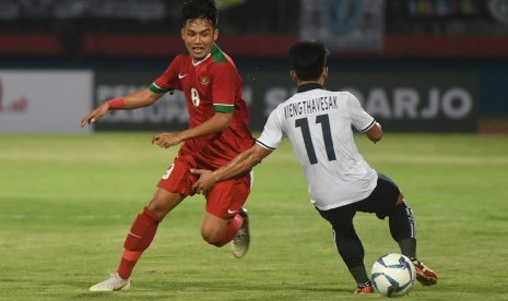 Pesepakbola Indonesia U19 Witan Sulaeman (kiri) berusaha merebut bola dari pesepakbola Laos U19 Kiengthavesak Xayxanapanya dalam penyisihan grup A Piala AFF U19 di Gelora Delta Sidoarjo, Sidoarjo, Jawa Timur, Minggu (1/7)