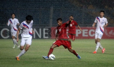   Pesepakbola Indonesia Zulfiandi (merah) berebur bola dengan pemain Korea Selatan dalam laga kualifikasi group G AFC U-19 di Gelora Bung Karno, Senayan, Jakarta, Sabtu (12/10).  (Republika/Yasin Habibi)