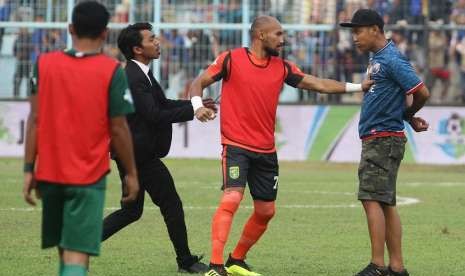 Pesepakbola Persebaya Surabaya, Alfonsius Kelvan (tengah) bersitegang dengan oknum suporter Arema FC (Aremania) yang memasuki lapangan saat istirahat babak pertama dalam pertandingan Liga I GOJEK antara Arema FC melawan Persebaya Surabaya di Stadion Kanjuruhan, Malang, Jawa Timur, Sabtu (6/10) 