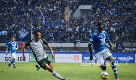 Pesepakbola Persib Bandung Ezechiel (kanan) berusaha melewati pesepakbola PS Tira Irfandi (kedua kiri) saat laga perdana Gojek Liga 1 di Stadion Gelora Bandung Lautan Api (GBLA), Bandung, Jawa Barat, Senin (26/3). 