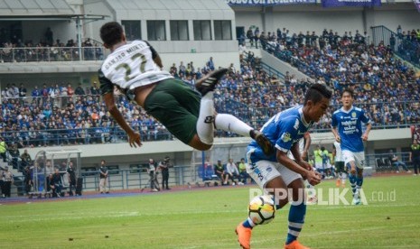 Pesepakbola Persib Bandung Febri Hariyadi (kedua kanan) berbenturan dengan pesepakbola PS Tira Ganjar Mukti (kiri) saat laga perdana Gojek Liga 1 di Stadion Gelora Bandung Lautan Api (GBLA), Bandung, Jawa Barat, Senin (26/3).