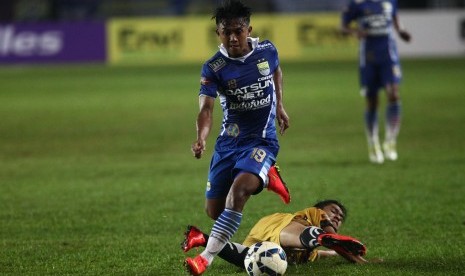 Pesepakbola Persib Bandung, Febri Hariyadi (kiri) berhasil melewati hadangan pesepakbola Mitra Kukar Maulana Bahtiar (bawah) pada laga perdana Liga Bhayangkara di Stasion Si Jalak Harupat,Kabupaten Bandung, Jawa Barat, Kamis (17/3).