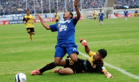 Pesepakbola Persib Bandung, Firman Utina (15) dijegal penjaga gawang Sriwijaya FC Rivky (33).