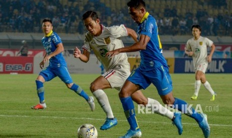 Pemain Persib Bandung Frets Butuan (kanan) berebut bola dengan pemain Persela Lamongan Ahmad Birrul dalam laga Liga 1 di Stadion Si Jalak Harupat, Selasa (3/12). Pelatih Persib Robert Alberts menilai timnya bermain buruk karena takluk 0-2 dari Persela.