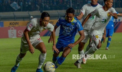 Pesepakbola Persib Bandung Frets Butuan (kanan) berebut bola dengan pesepakbola Persela Lamongan Ahmad Birrul (kiri) saat menjalani laga lanjutan Liga 1 di Stadion Si Jalak Harupat, Kabupaten, Bandung, Jawa Barat, Selasa (3/12/2019).