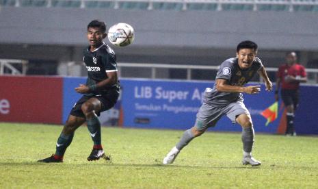 Pesepakbola Persikabo 1973 Syahrul Lasirani (kiri) berebut bola dengan pesepakbola Persebaya Sho Yamamoto (kanan) dalam laga Liga 1 di Stadion Pakansari, Kabupaten Bogor, Jawa Barat, Senin (25/7/2022). 