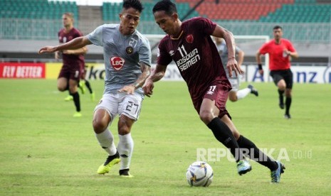 Pesepakbola PSM Makassar M Rahmat (kanan) berebut bola dengan pesepakbola Kaya FC Iloilo Felonggo (kiri) dalam penyisihan grup H piala AFC 2019 di Stadion Pakansari, Bogor, Jawa Barat, Selasa (2/4/2019). 