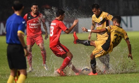 Pesepakbola Semen Padang Adi Nugroho (tengah) berebut bola dengan pesepakbola Mitra Kukar Syahrizal (kanan) dan Hendra Ridwan (kedua kanan) saat laga Final Piala Jenderal Sudirman di Stadion Utama Gelora Bung Karno, Jakarta, Ahad (24/1). 