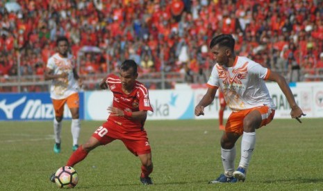 Pesepakbola Semen Padang FC, Riko Simanjuntak (kiri) menggiring bola dibayangi pemain Perseru Serui, Moch Zaenuri (kanan), pada pertandingan pekan ke-32, Liga 1 Gojek Traveloka di Stadion GOR H Agus Salim, Padang, Sumatera Barat, Sabtu (28/10). Semen Padang FC mengalahkan Perseru 3-1. 