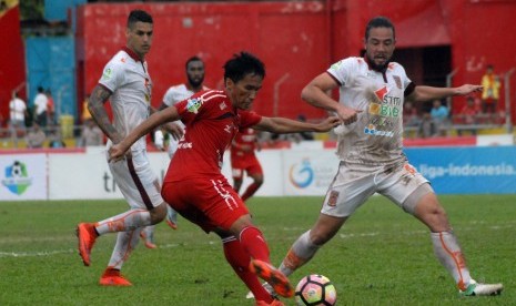 Pesepakbola Semen Padang FC, Rudi (kiri) melepaskan tendangan dibayangi pemain Pusamania Borneo FC, Yamashita Kunihiro (kanan), pada pertandingan lanjutan Liga 1, di Stadion GOR H Agus Salim Padang, Sumatera Barat, Kamis (31/8). 