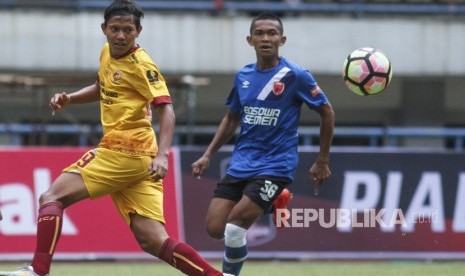 Pesepakbola Sriwijaya FC Adam Salis (kiri) berebut bola dengan pesepakbola PSM Makassar Ahmad Hari (kanan) pada laga lanjutan Grup A Piala Presiden 2018 di Stadion Gelora Bandung Lautan Api, Bandung, Jawa Barat, Ahad (21/1). 