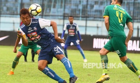 Pesepakbola Sriwijaya FC, Esteban Vizcarra (kanan) berusaha menghalau bola dari pesepakbola Arema FC, Hamka Hamzah (kiri) dalam pertandingan Liga I GOJEK di Stadion Kanjuruhan, Malang, Jawa Timur, Ahad (9/12/2018).