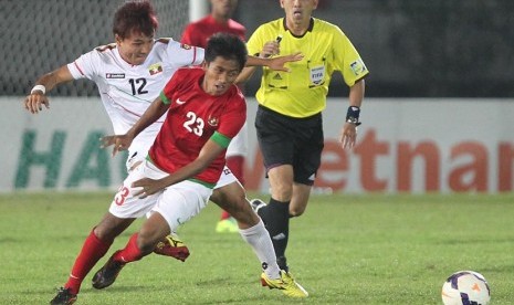  Pesepakbola timnas Indonesia Bayu Gatra (kanan) berebut bola dengan pesepakbola Myanmar Nay Phyo Aung (kiri) saat penyisihan grup B Sea Games ke-27 di stadion Youth Training Center, Yangon, Myanmar, Senin (16/12). 