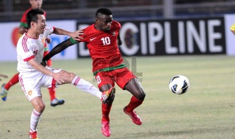 Pesepakbola timnas Indonesia, Greg Nwokolo berusaha melewati pemain Cina saat laga kualifikasi Piala Asia 2015 di Stadion Utama Gelora Bung Karno, Jakarta, Selasa (15/10).  (Republika/ Wihdan)