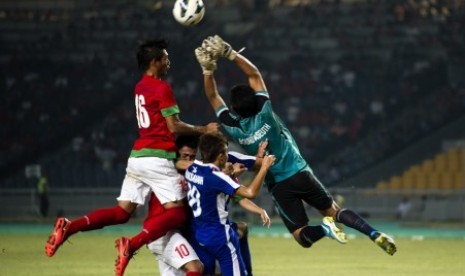 Pesepakbola timnas U-19 Indonesia, Hansamu Yama Pratama (kiri) dan penjaga gawang Laos, Bounpaseuth Niphavong (kanan), berjibaku berebut bola saat laga grup G kualifikasi Piala Asia (AFC) U-19 di Stadion Gelora Bung Karno, Senayan, Jakarta, Selasa (8/10) m