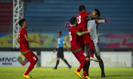   Pesepakbola timnas U-23 Indonesia memeluk penjaga gawang Indonesia, Kurnia Meiga Hermansyah (kanan) dalam semi final sepak bola ISG III di Stadion Gelora Sriwijaya Jakabaring, Palembang, Jumat (27/9). 