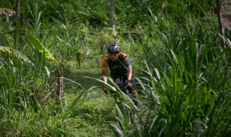 Pesepeda melintasi perkebunan di Pakem, Sleman, DI Yogyakarta, Sabtu (2/10/2021). Paket wisata bersepeda yang menawarkan berkeliling kota dan pedesaan tersebut sebagai upaya membangkitkan tren sport tourism di Yogyakarta.